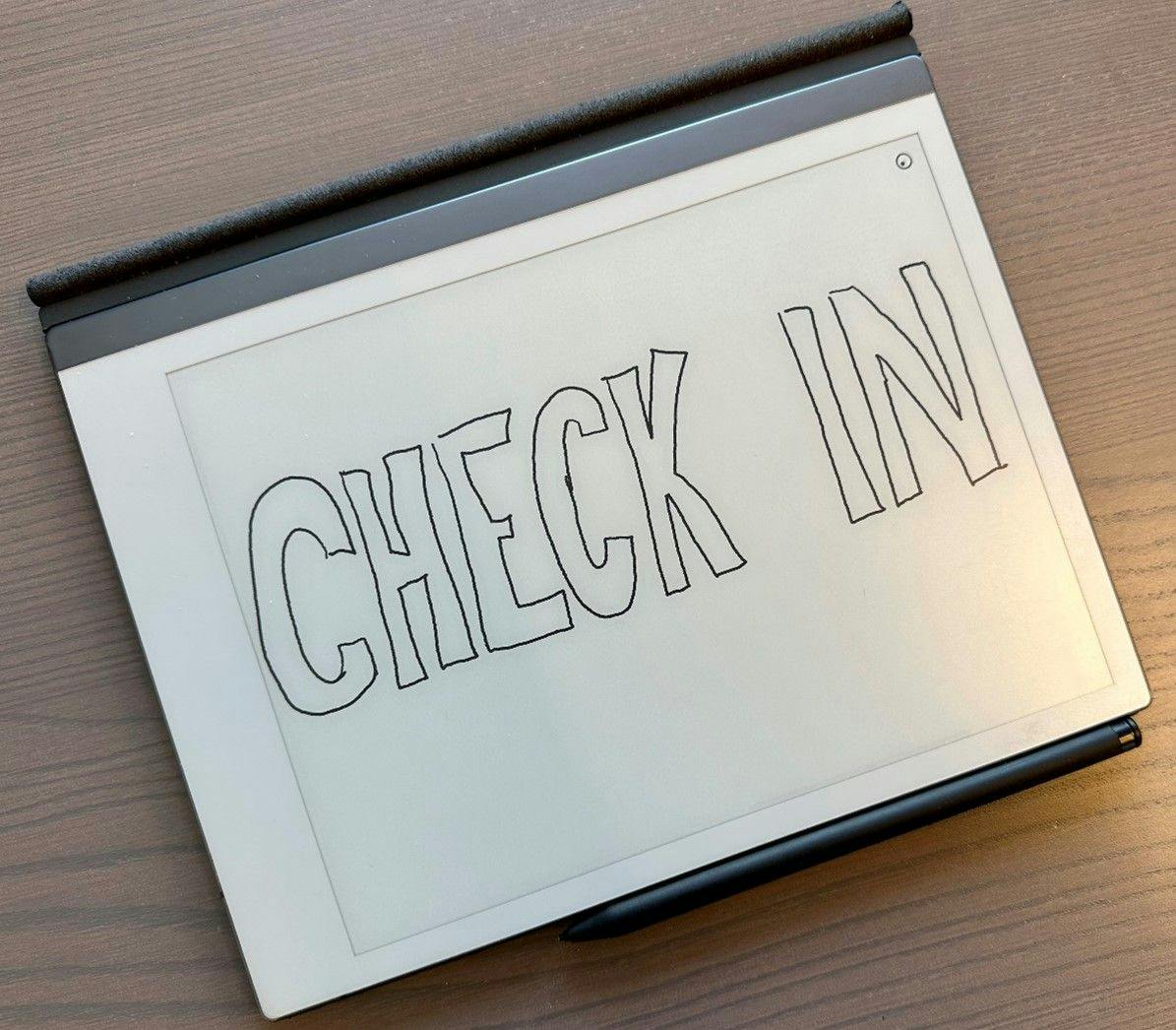 Teksten "Check-in" er skrevet med mørk tekst på en tablet