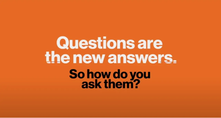 Hvit tekst på organge bakgrunn, med teksten "questions are the new answers"